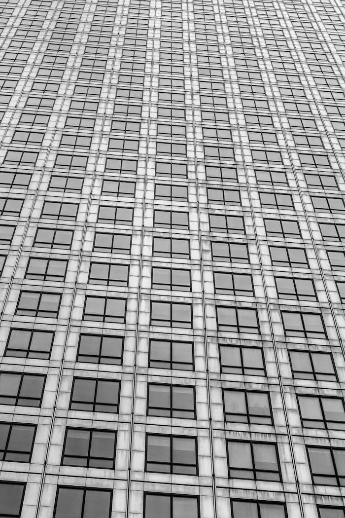 A dynamic low-angle view of a modern skyscraper facade with glass windows.